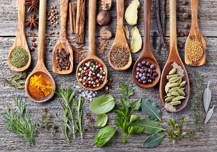 spices and herbs on wooden spoons
