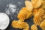 salty potato chips on dark background