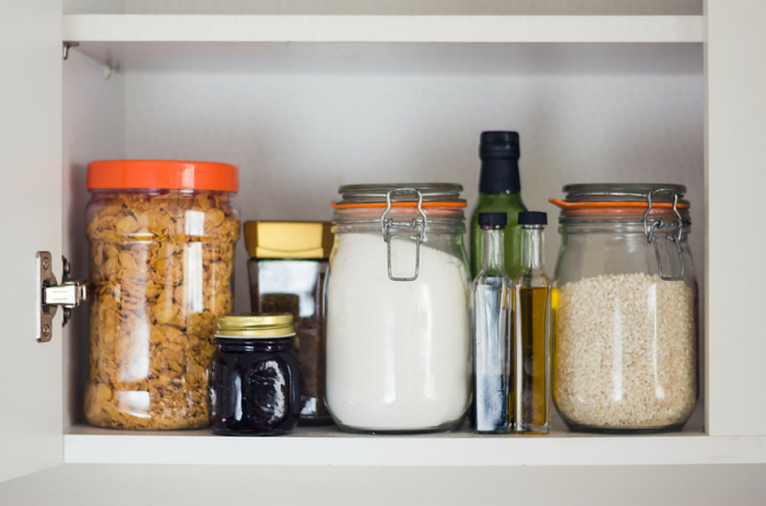 Jars with food ingredients in white pantry