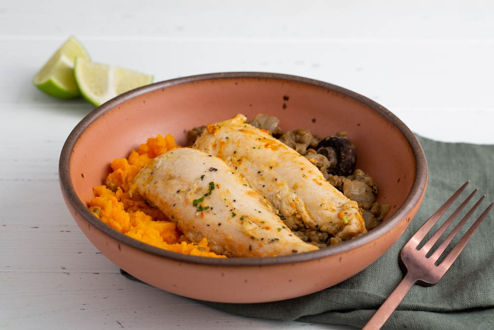 cage-free chicken in a bowl with seasoning and vegetables