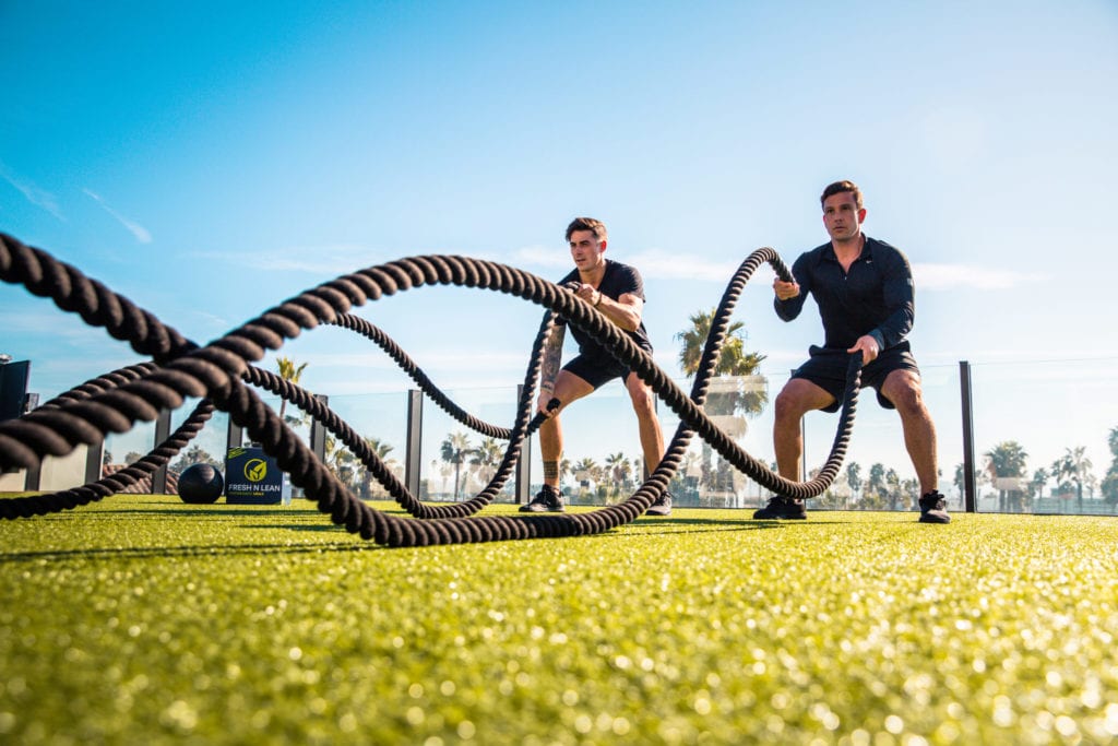 two men using workout ropes
