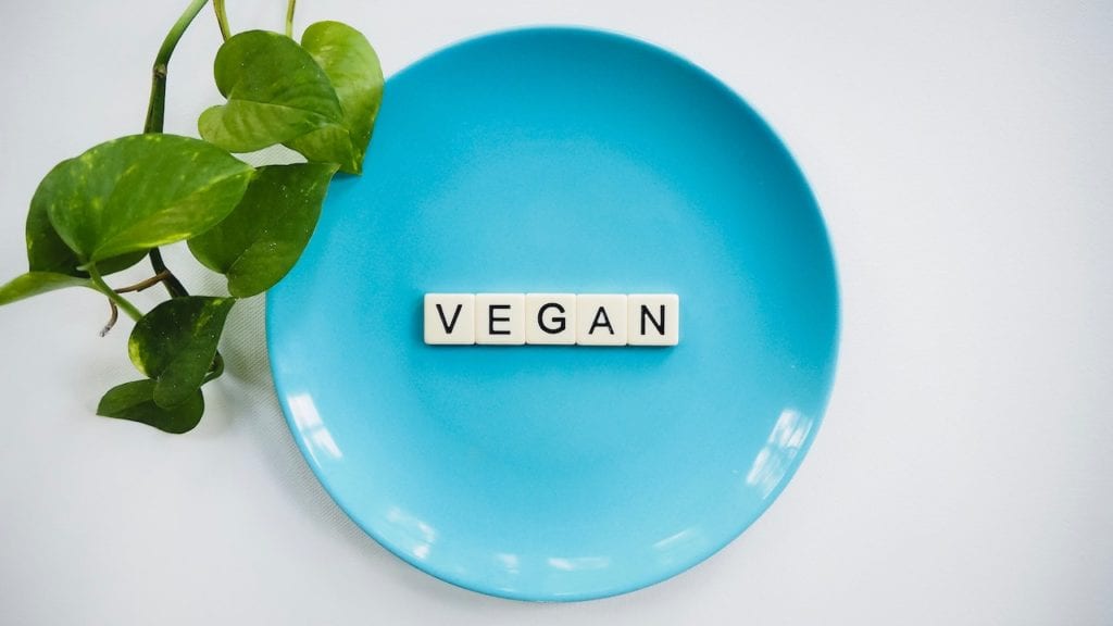 Blue plate with the word "vegan" in the center. 