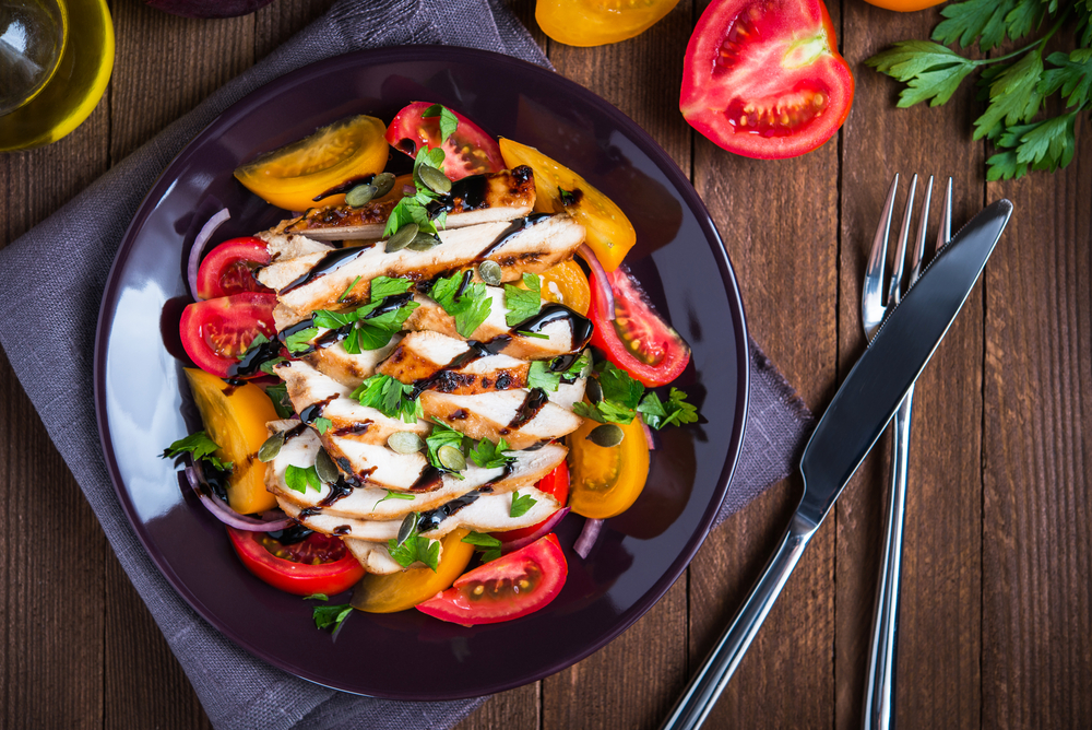 A keto-diet friendly dish with chicken, tomatoes, onions, and balsamic dressing