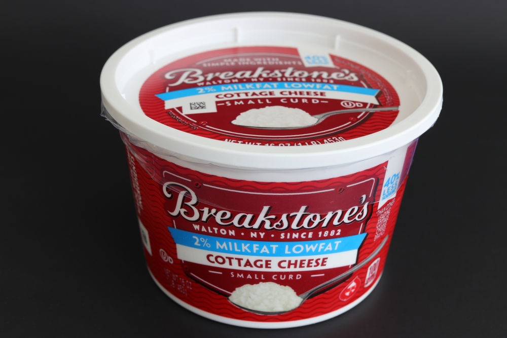 Breakstone's brand 2% low fat cottage cheese container sealed and isolated on a black background. 